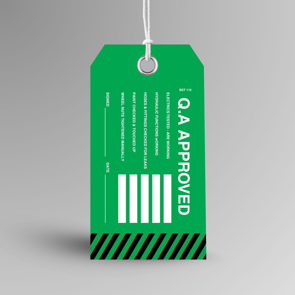 BST 115 Q.A Approved Tag upright view showing green tag with bold white Q.A Approved text and black hazard stripe detail on front face