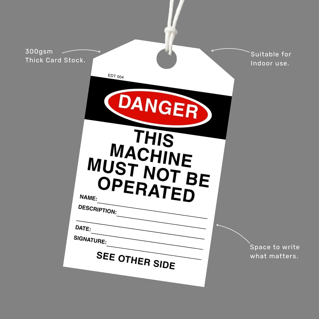 Danger This Machine Must Not Be Operated tag printed on 300gsm thick card stock with an attached white cord, callout labels highlighting indoor suitability and write-in fields.